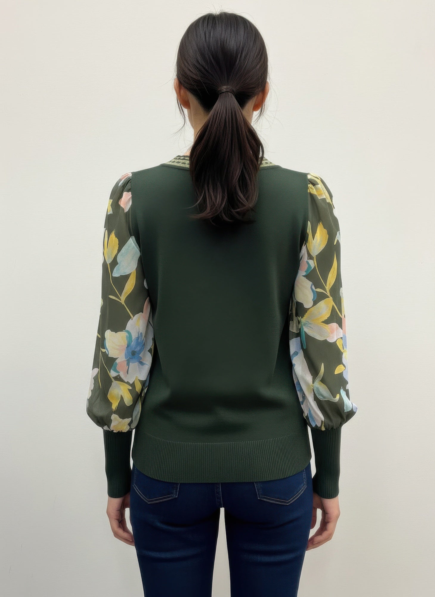 Person wearing a green rio & rian sweater with floral sleeves back view
