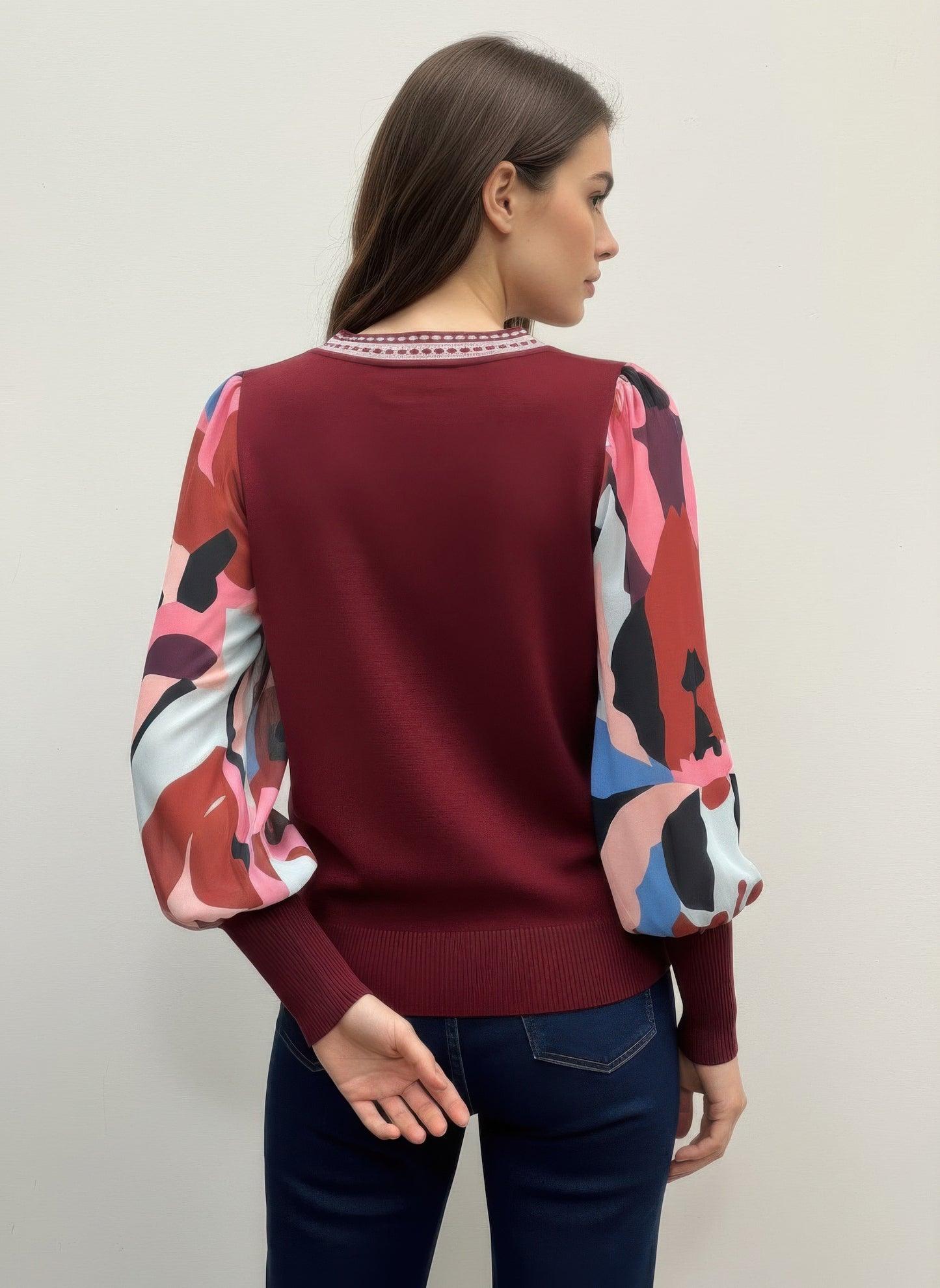 Woman wearing a burgundy rio & rian sweater with colorful sleeves back view