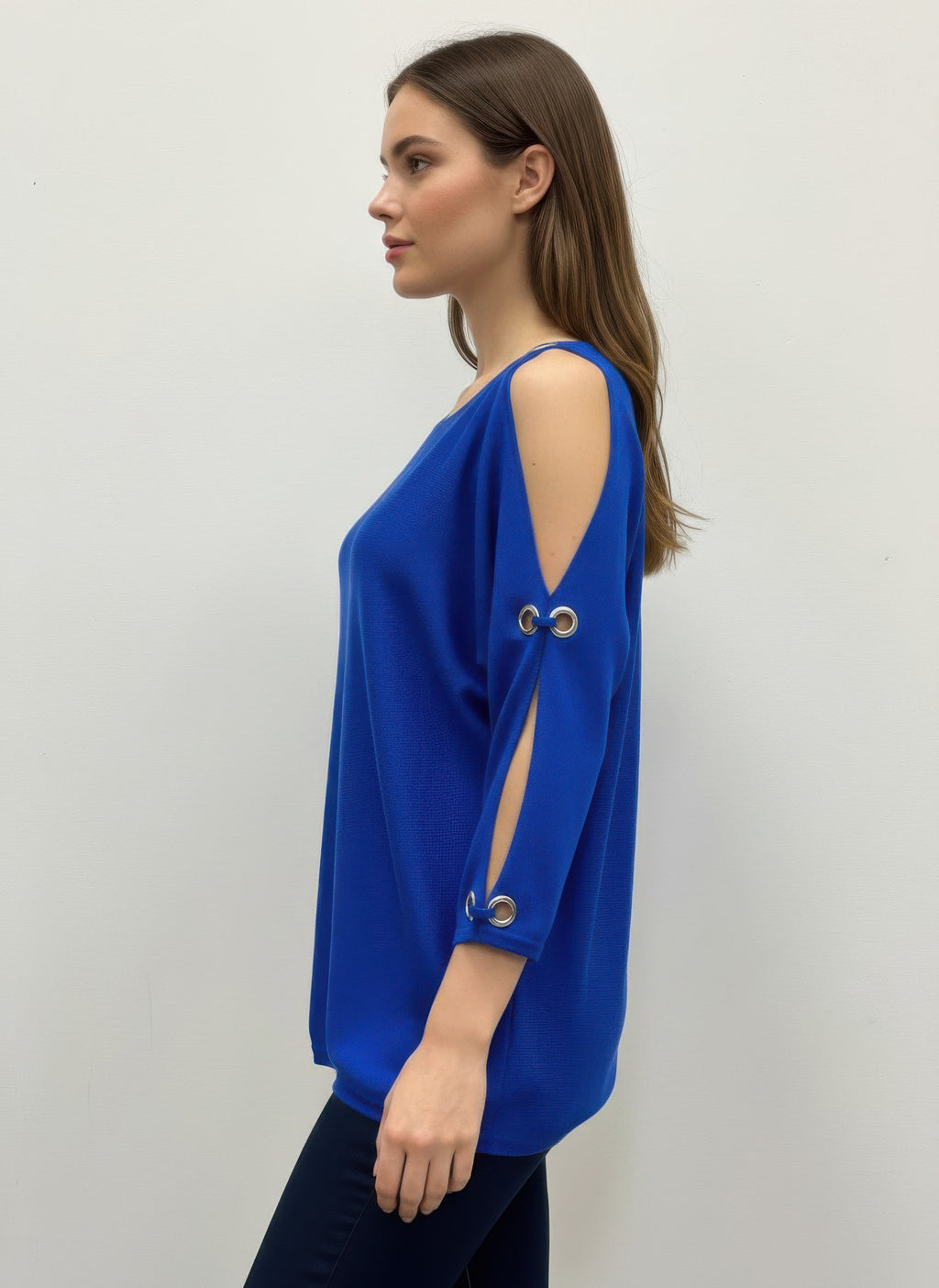Woman wearing a blue Cable & Gauge Pullover Sweater with cut-out shoulders. Side view 
