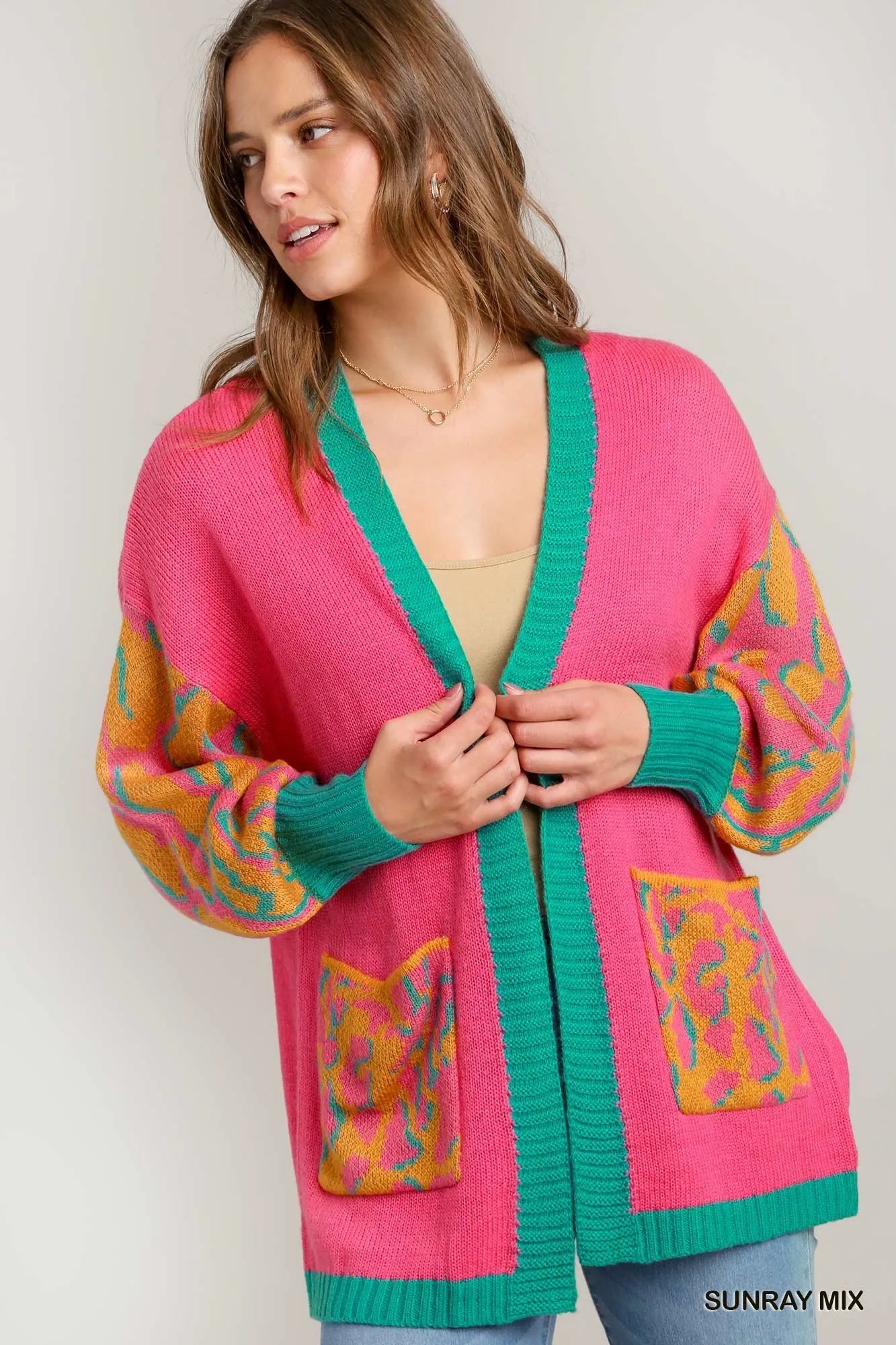 Model holding the cardigan, showing the cozy knit and bold colors.