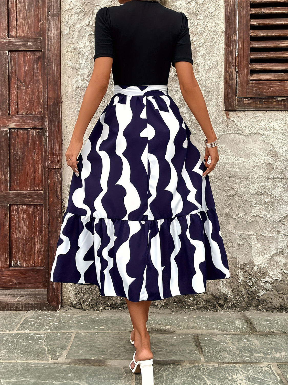 Model wearing dark blue & white maxi dress back view