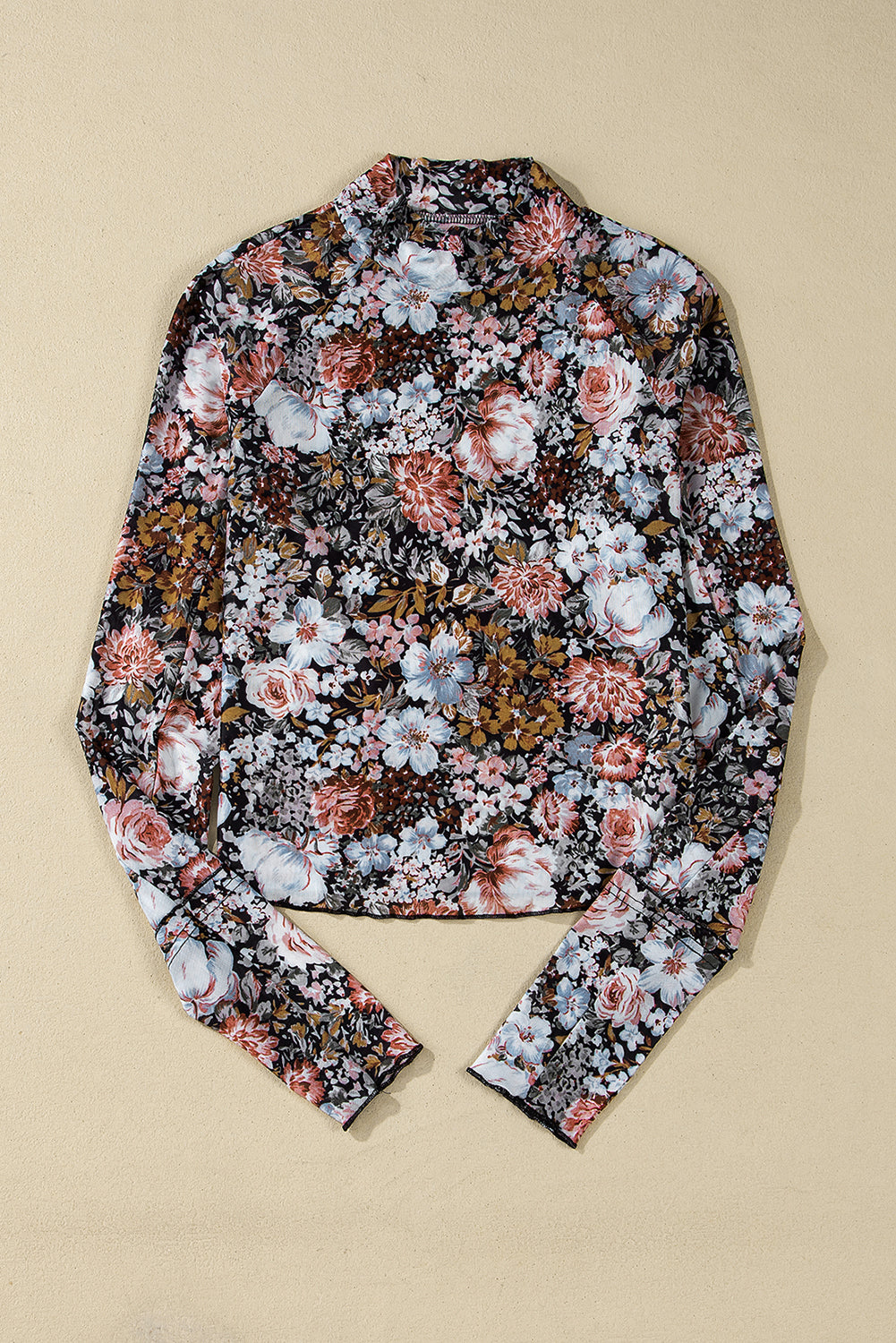 Top laid flat showing the floral design and mock neck.