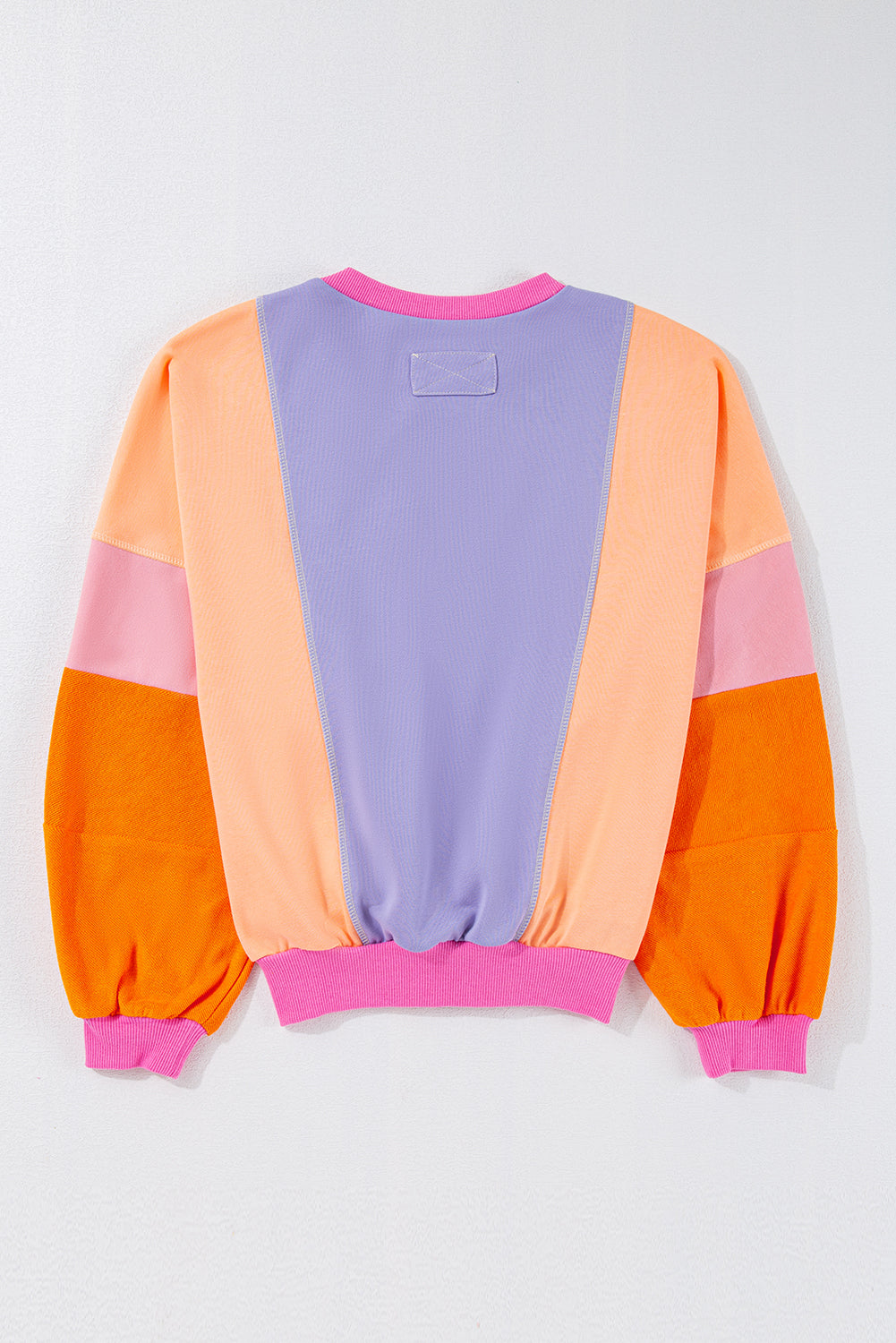 Front view of a vibrant colorblock sweatshirt featuring bold colors: pink, orange, and blue.