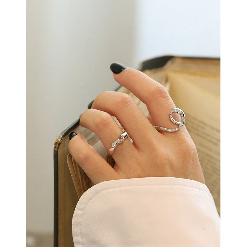 Model finger wearing heart knot silver rhodium ring