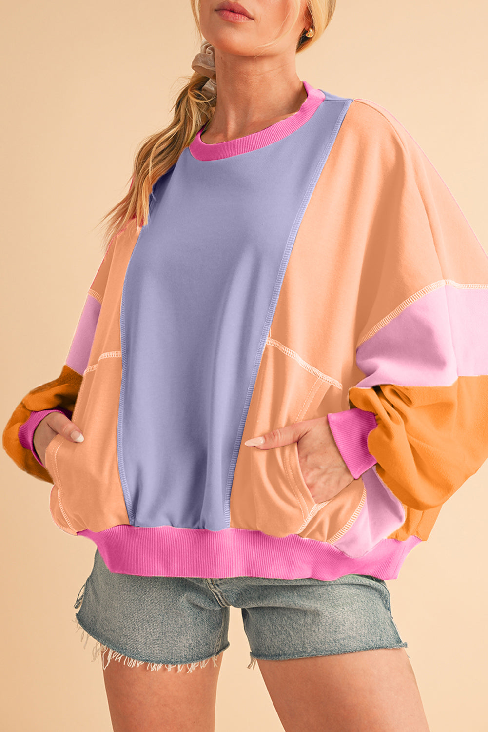 Person wearing a colorful sweater with a beige background
