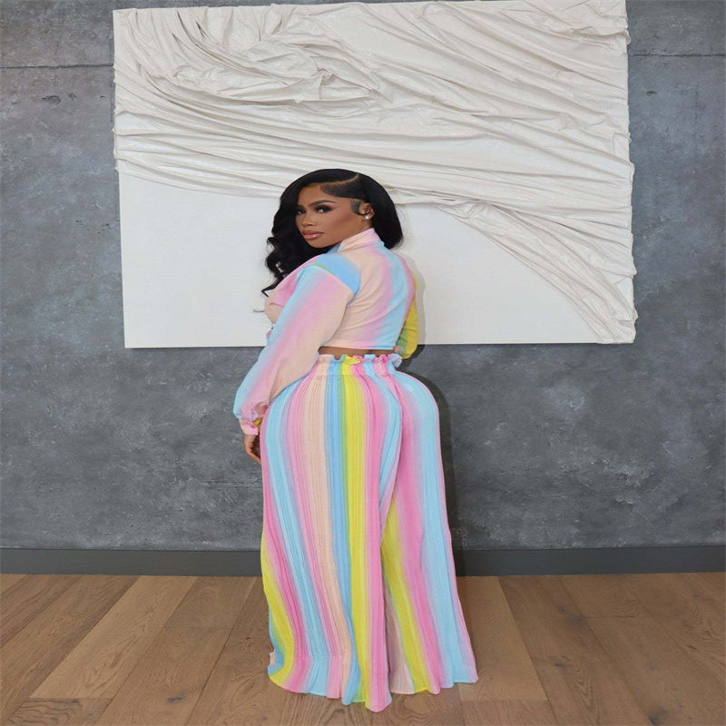 Model wearing a pastel rainbow two-piece outfit with wide-leg pleated pants and a tie-front crop top, showcasing bold vibrant colors with soft elegance.