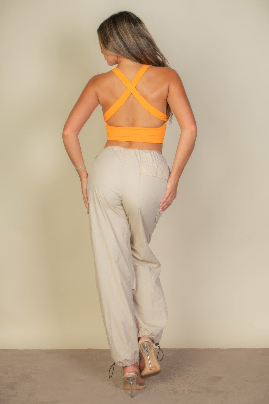 Woman wearing a ribbed knit plunged orange top back view
