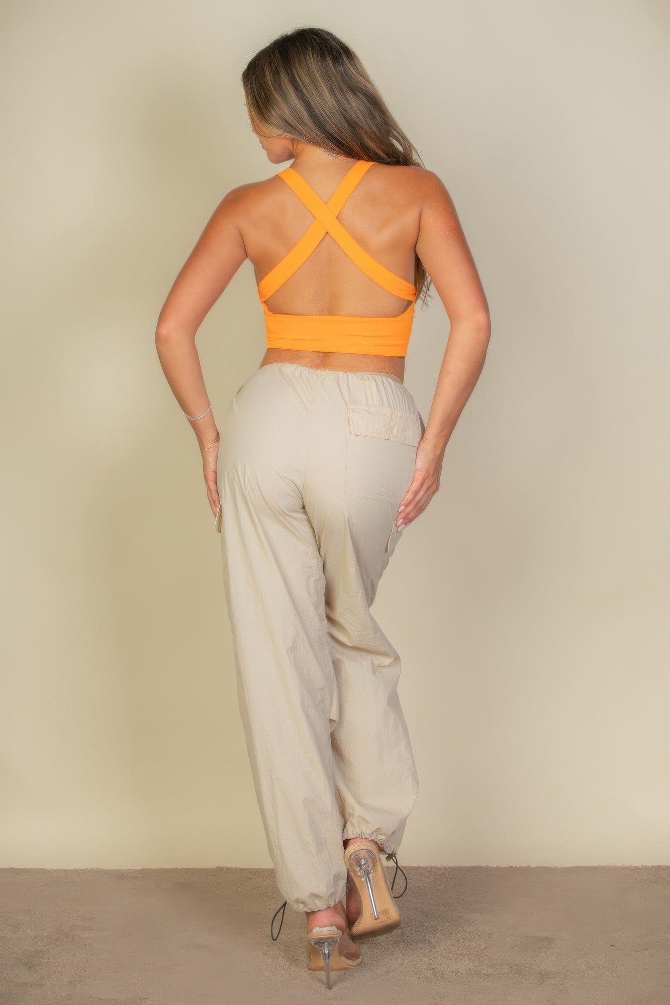 Woman wearing a ribbed knit plunged orange top back view