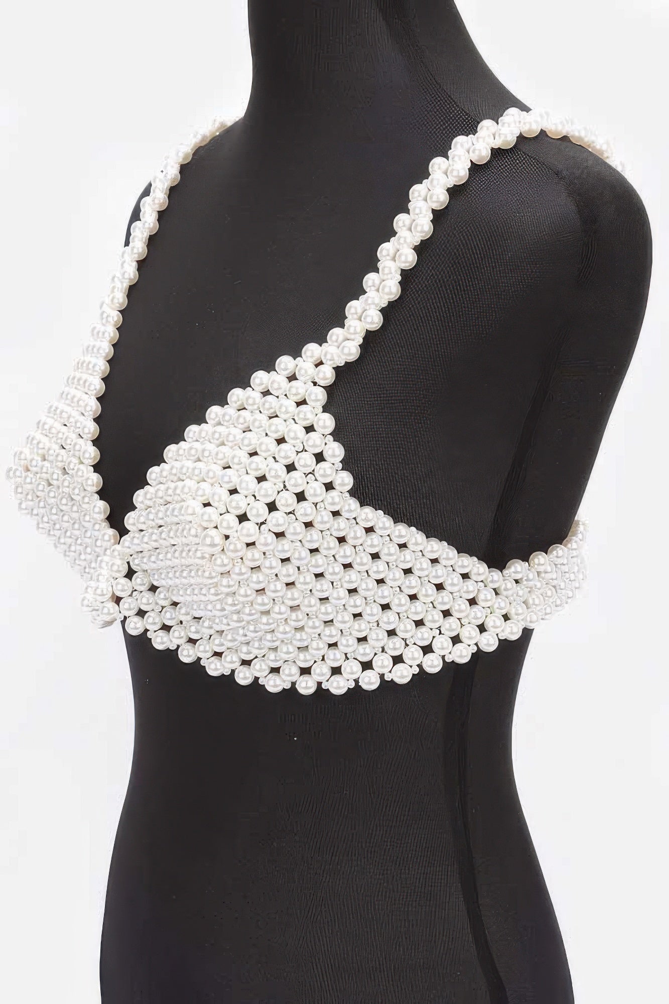 Pearl-studded top on a mannequin against a white background