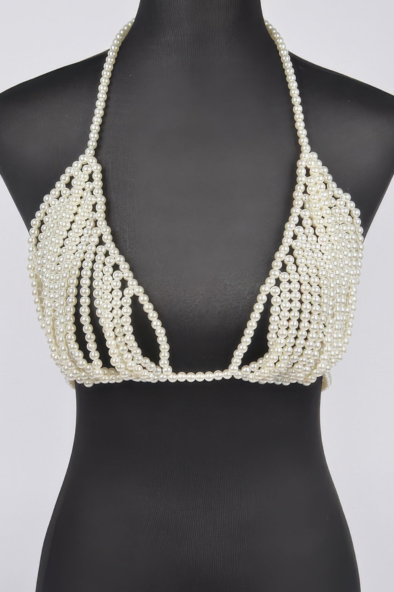 Pearl-beaded bikini top on a black mannequin against a white background