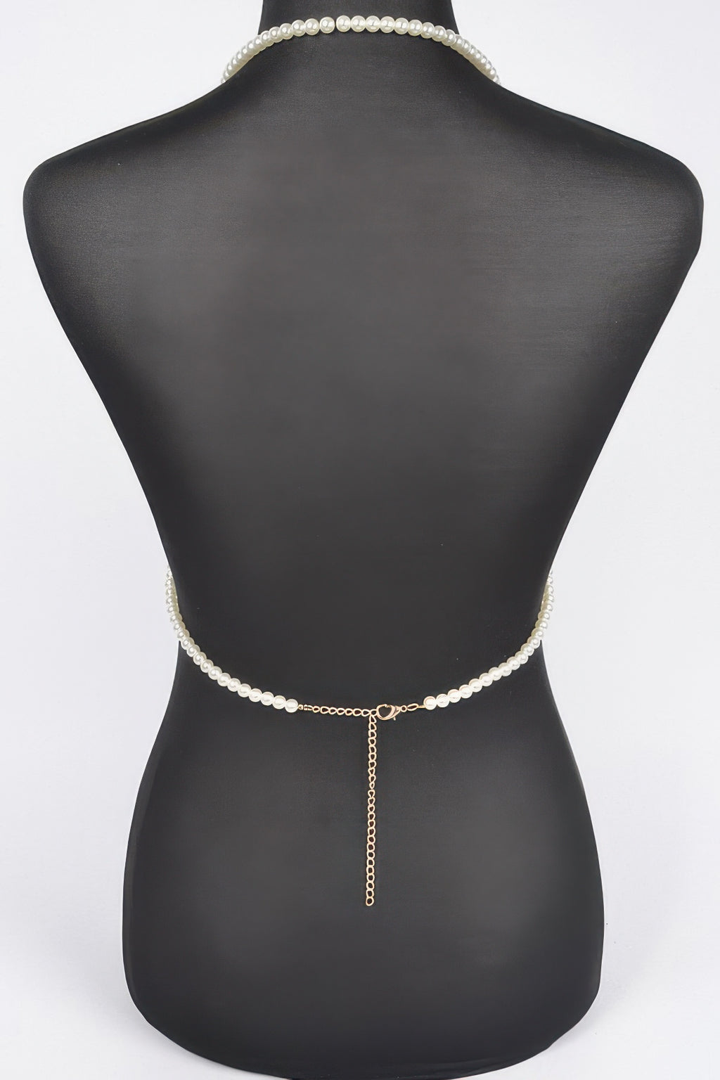 Pearl belt with a chain on a mannequin against a white background