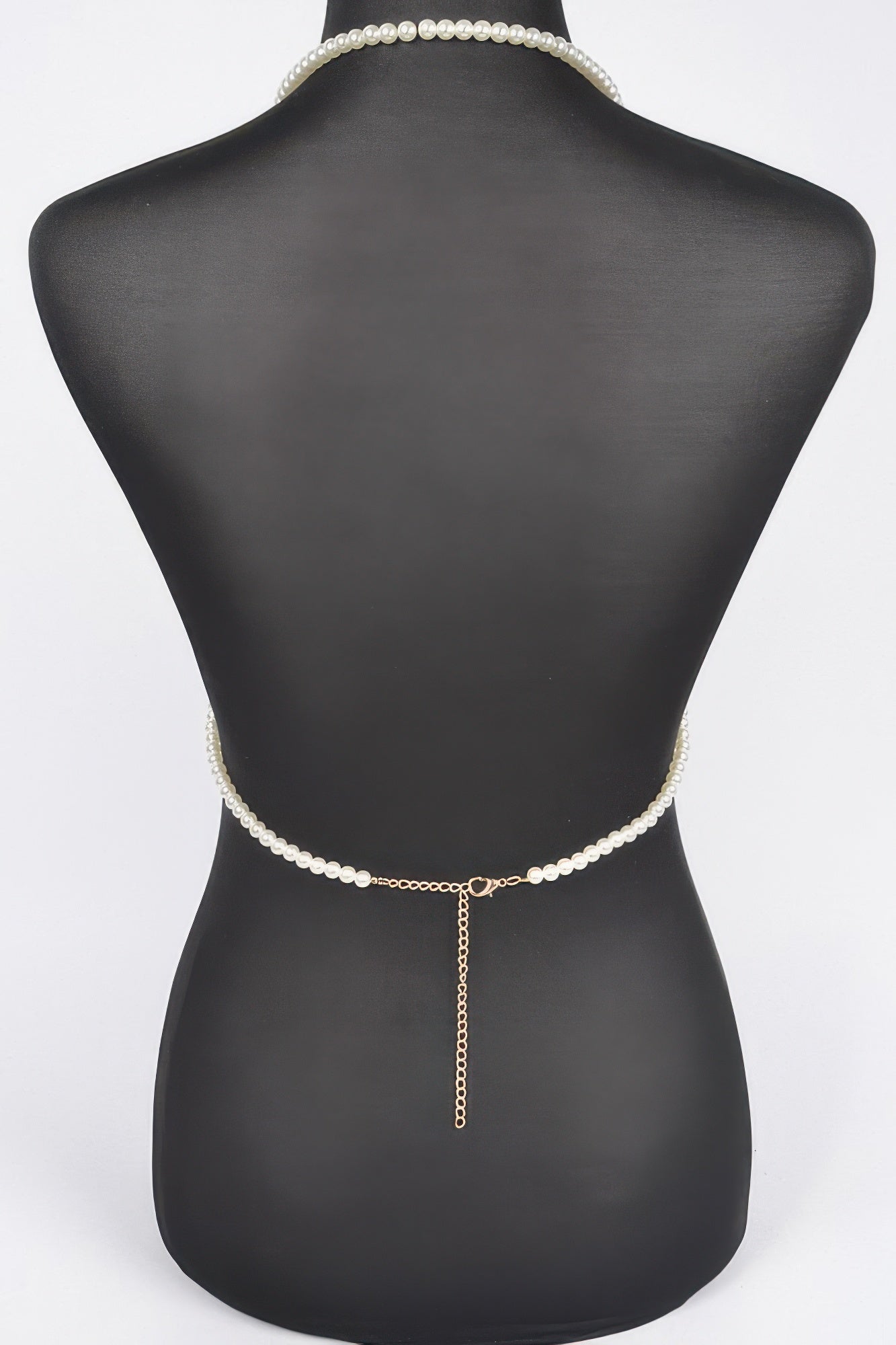 Pearl belt with a chain on a mannequin against a white background