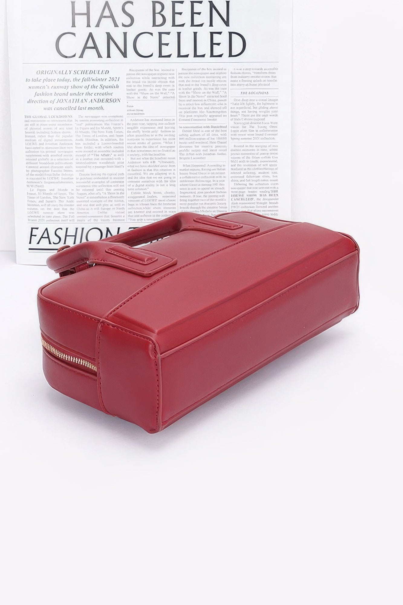 Red handbag on a white background with text overlay bottom view
