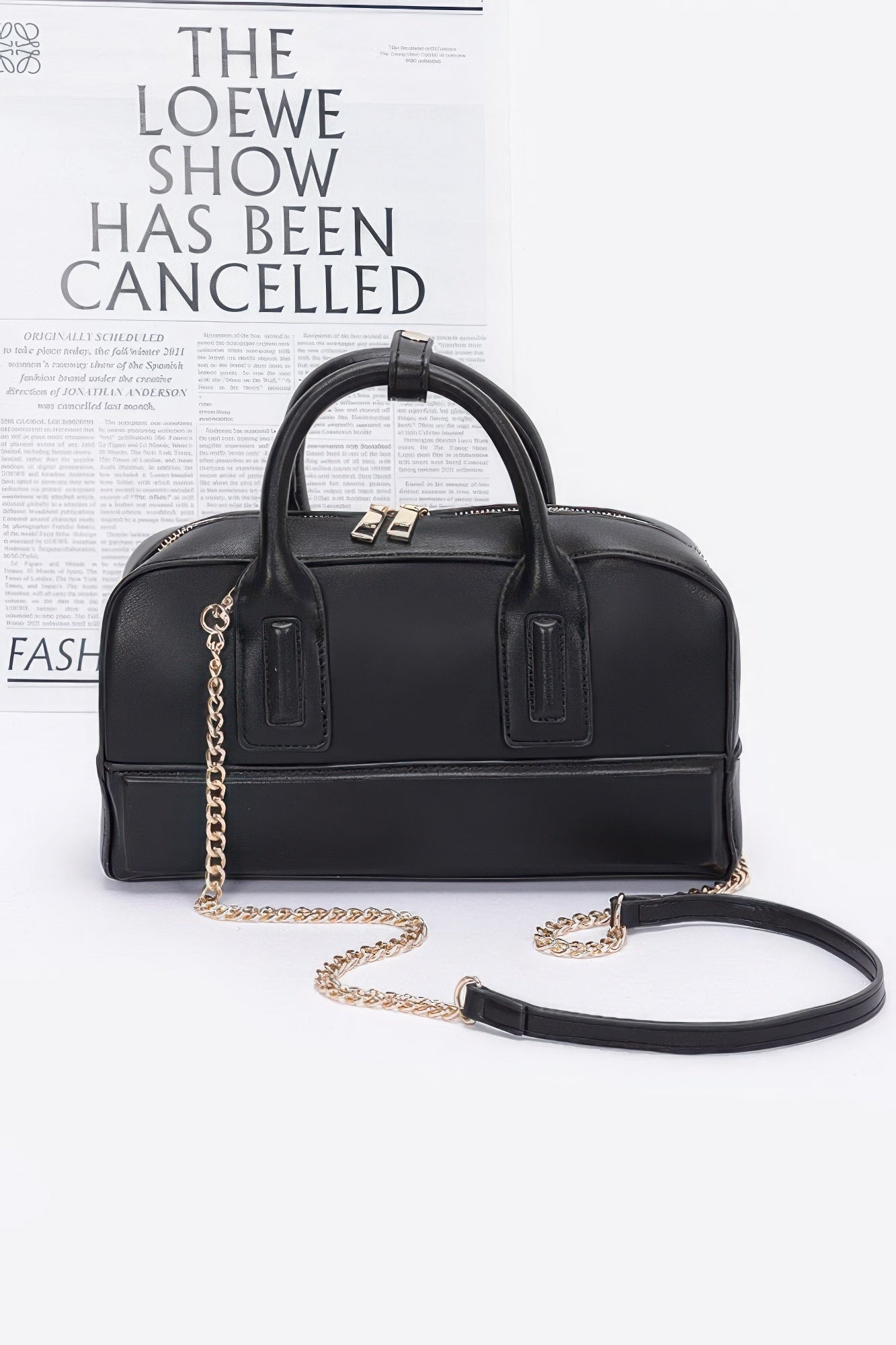 Black handbag with gold chain on a white background