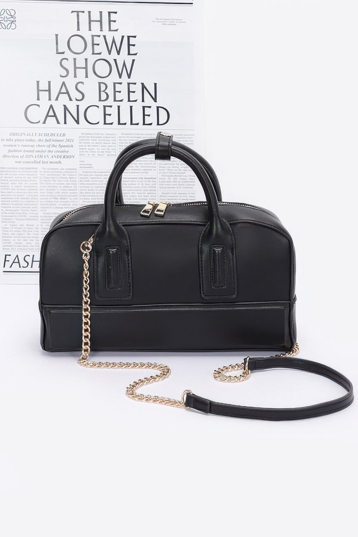 Black handbag with gold chain on a white background