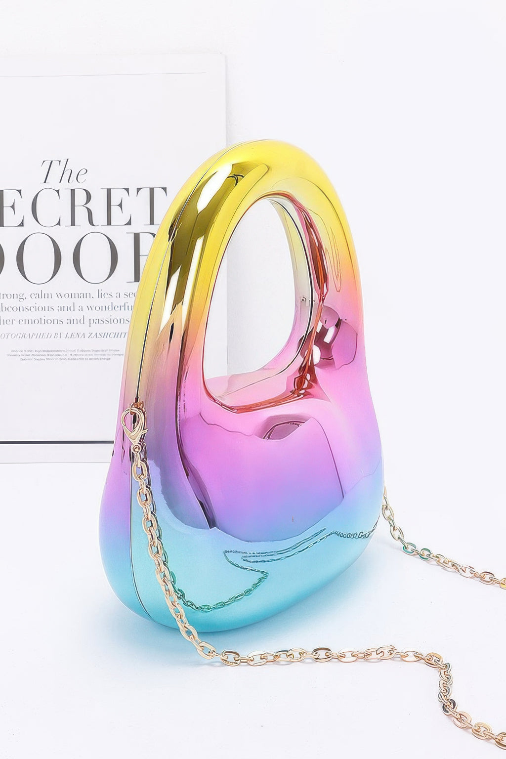 Multicolored handbag with a chain strap on a light background side view
