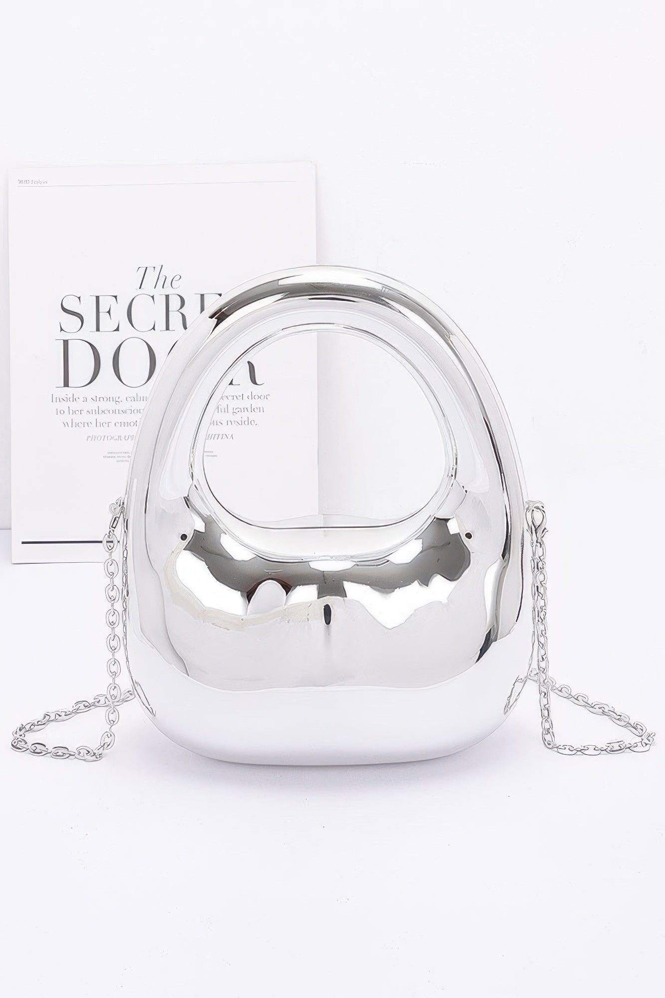 Silver handbag with chain detail on a white background