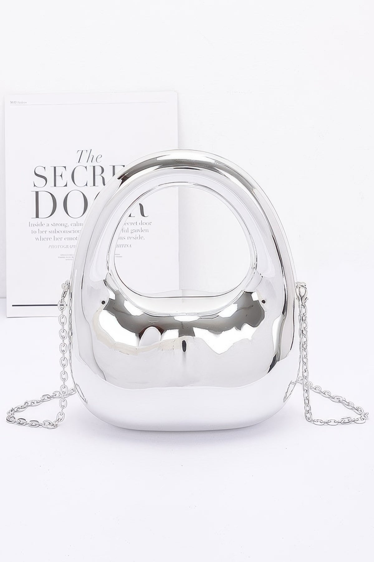 Silver handbag with chain detail on a white background