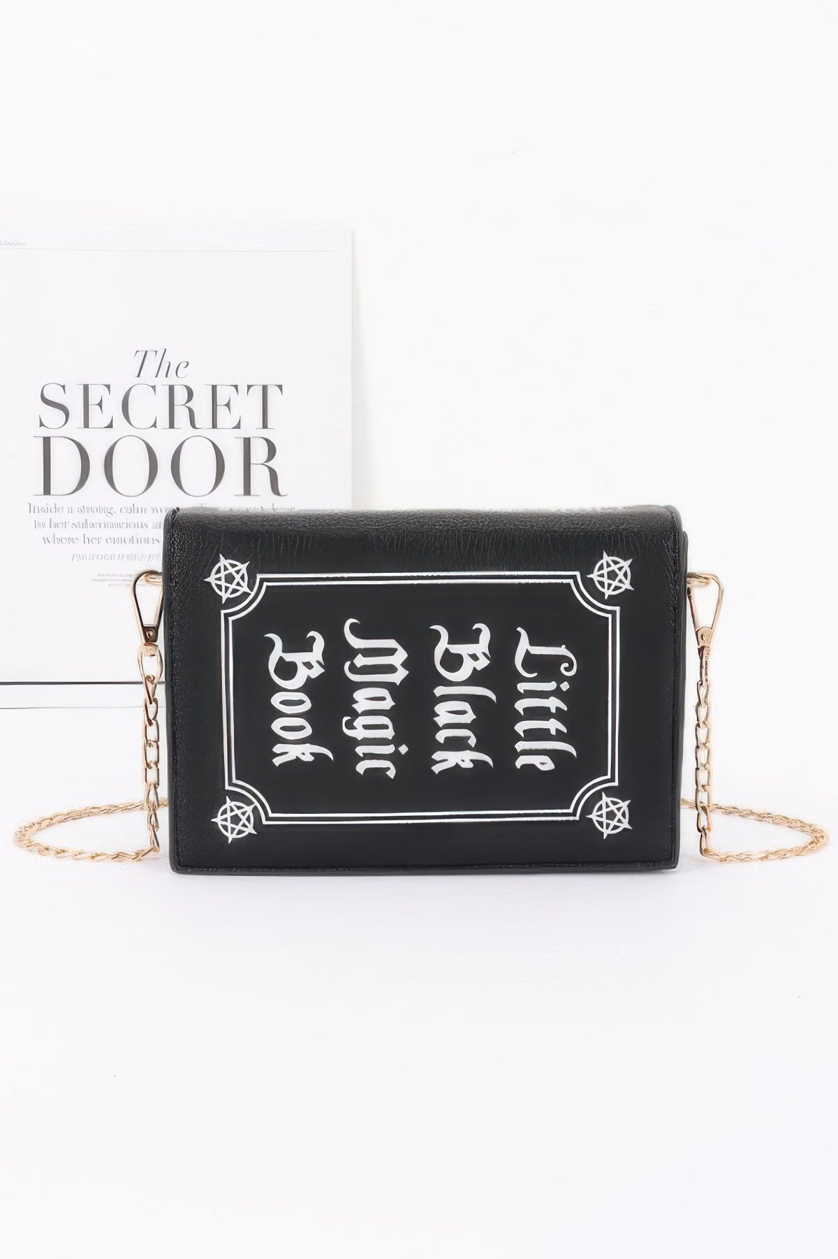 Black clutch with 'Little Black Magic Book' in white text 