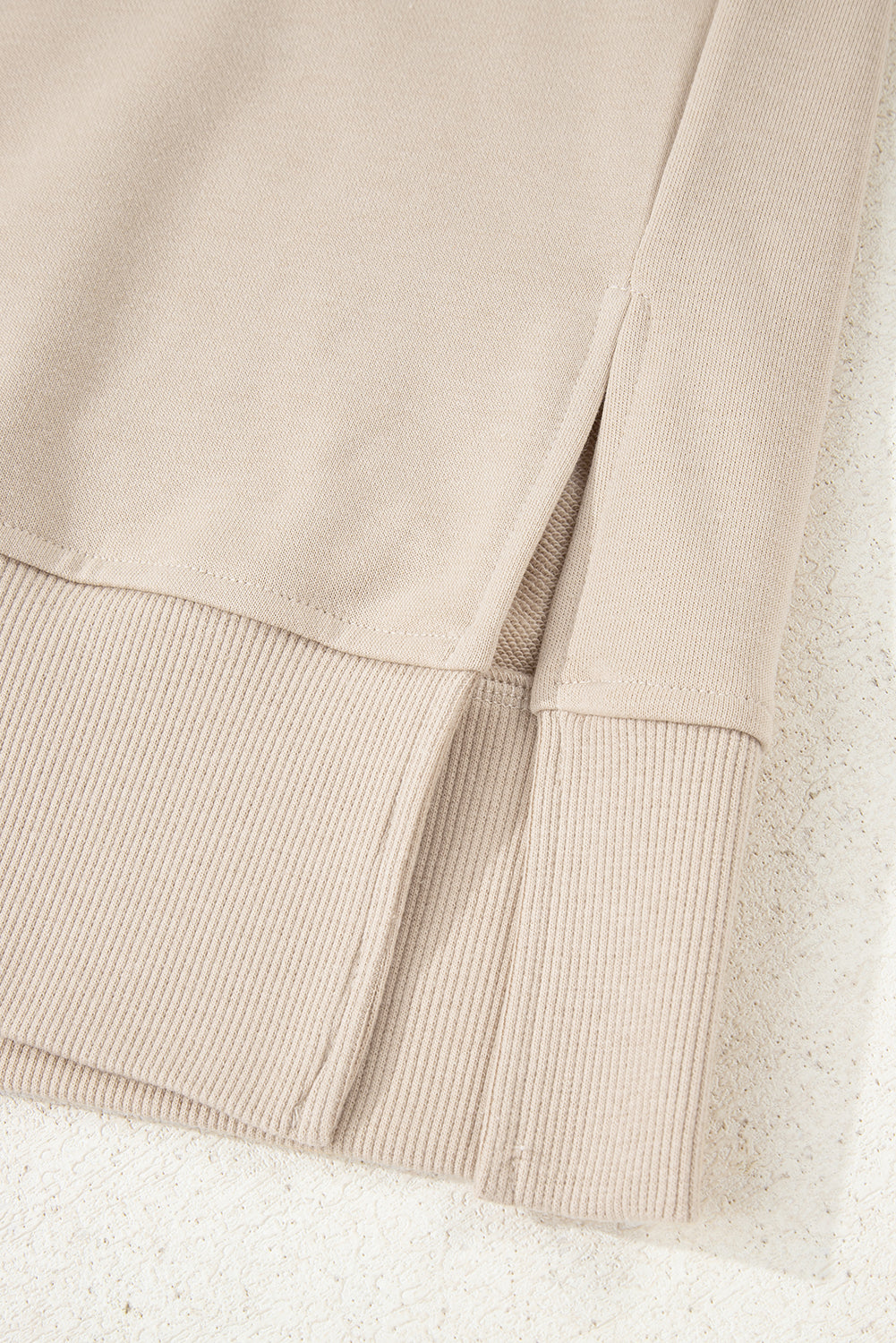 Close-up of beige fabric with a textured pattern on a light background