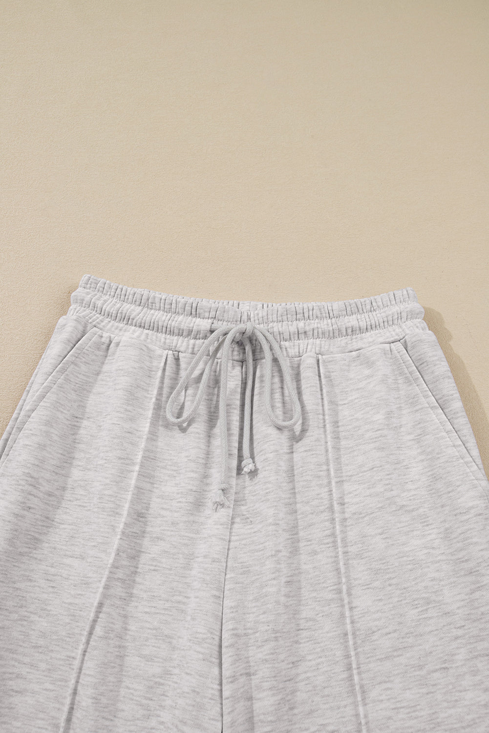 Gray sweatpants with a drawstring on a beige background