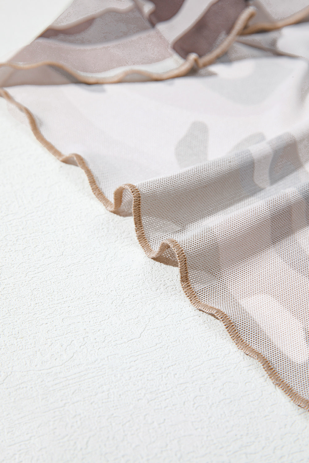 Close-up of a sheer fabric with a textured background