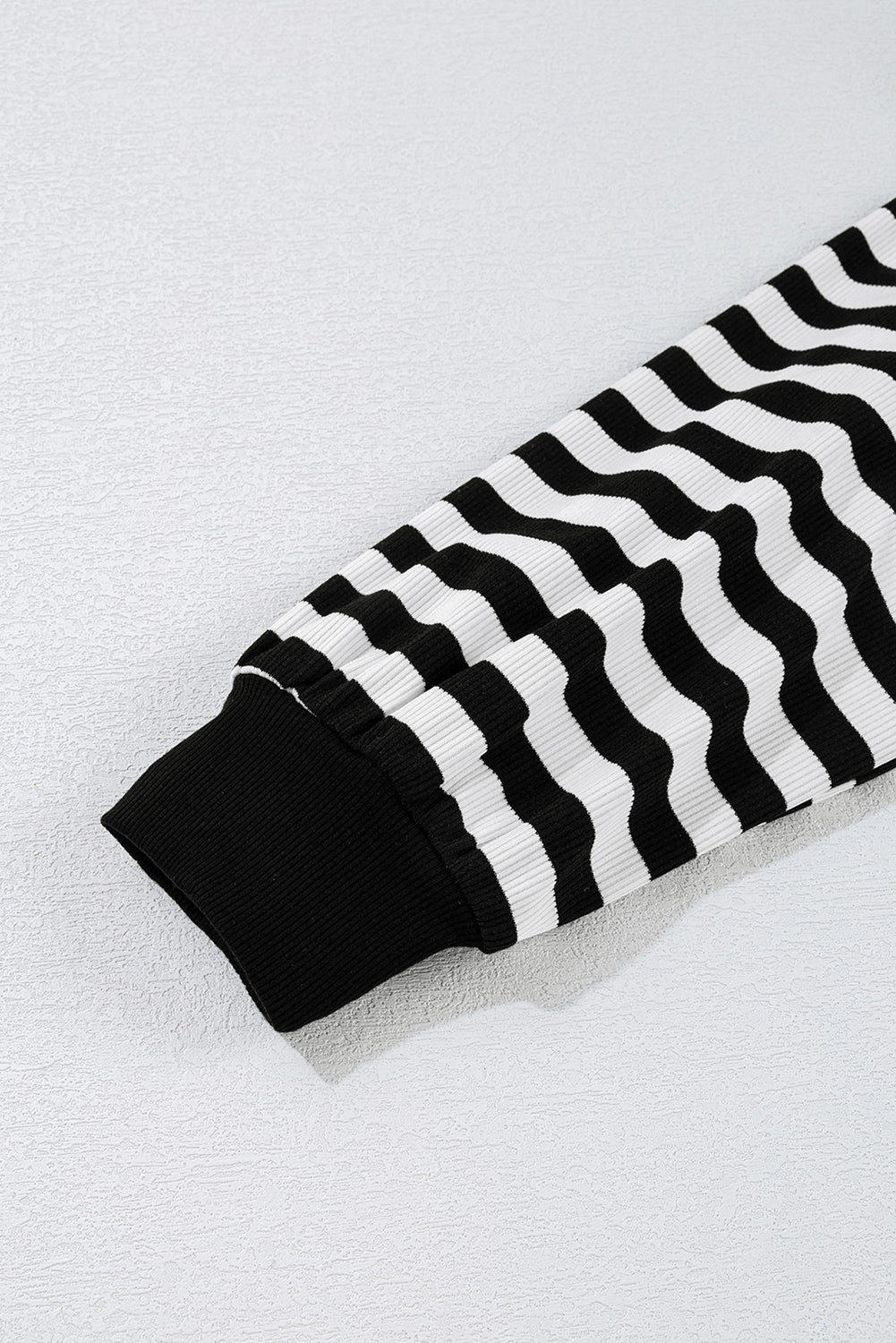 Black and white striped fabric on a light gray background