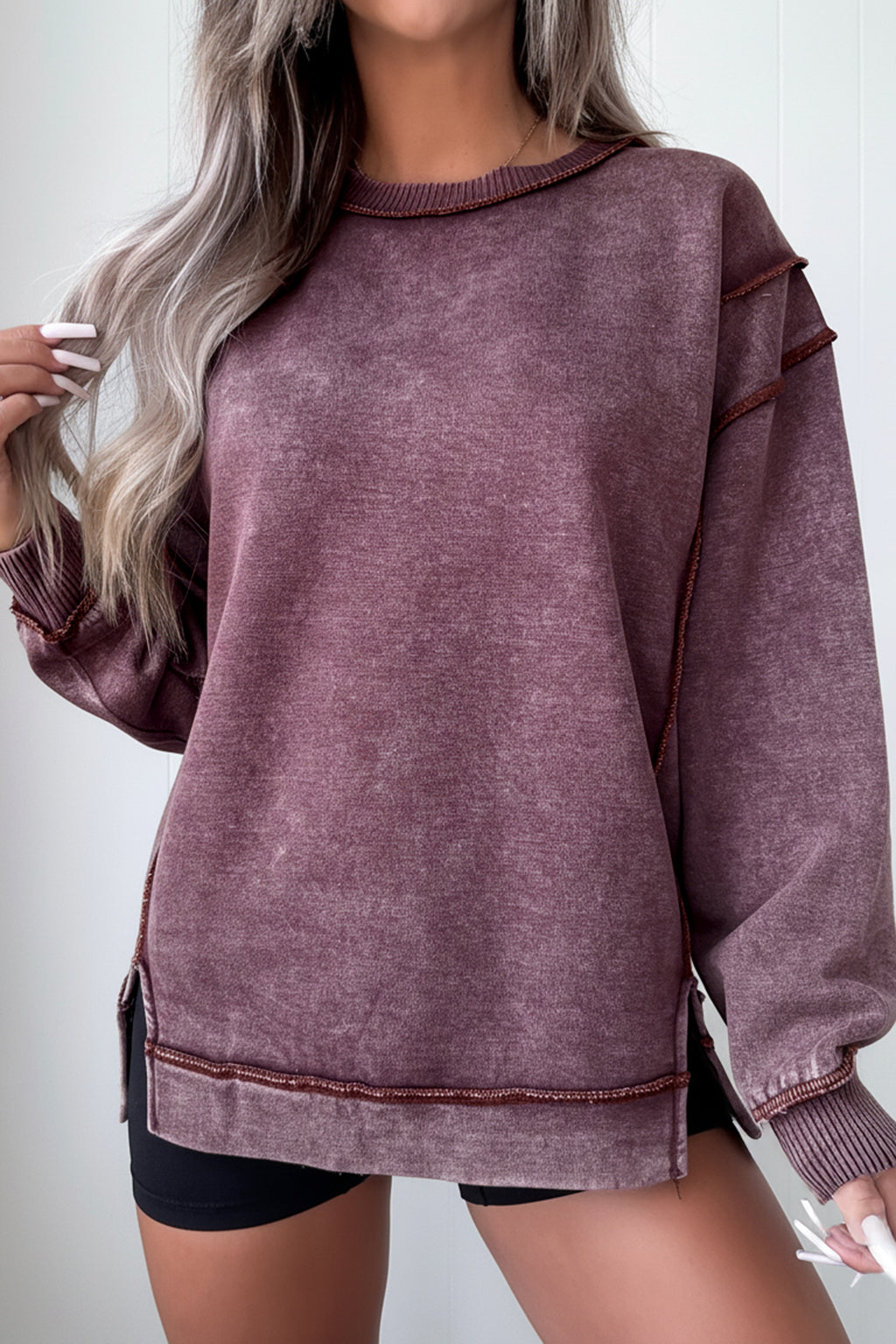 Person wearing a maroon sweatshirt with a plain background