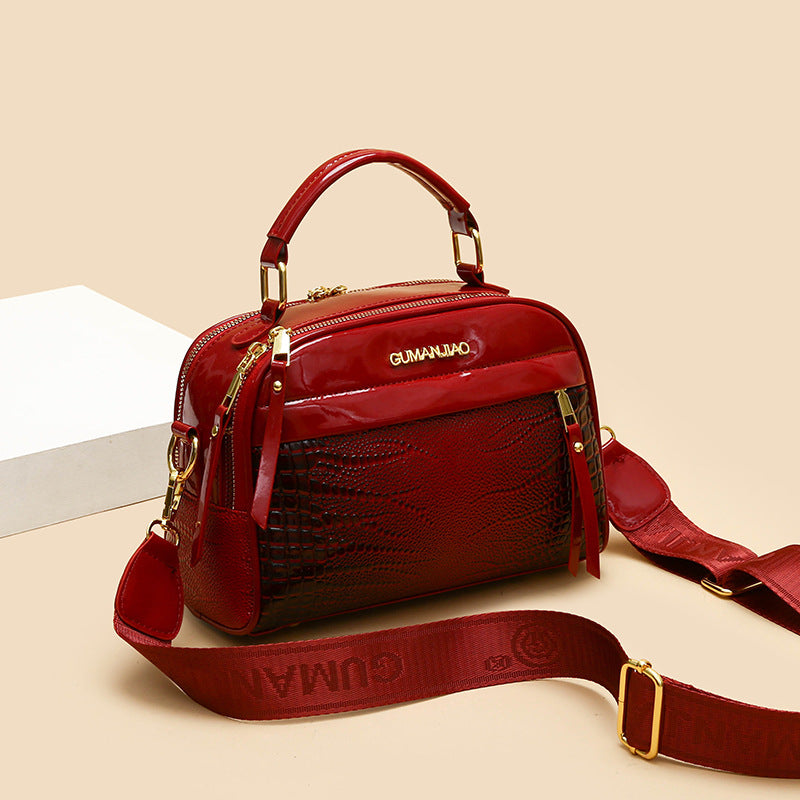 Red handbag with gold accents on a beige background