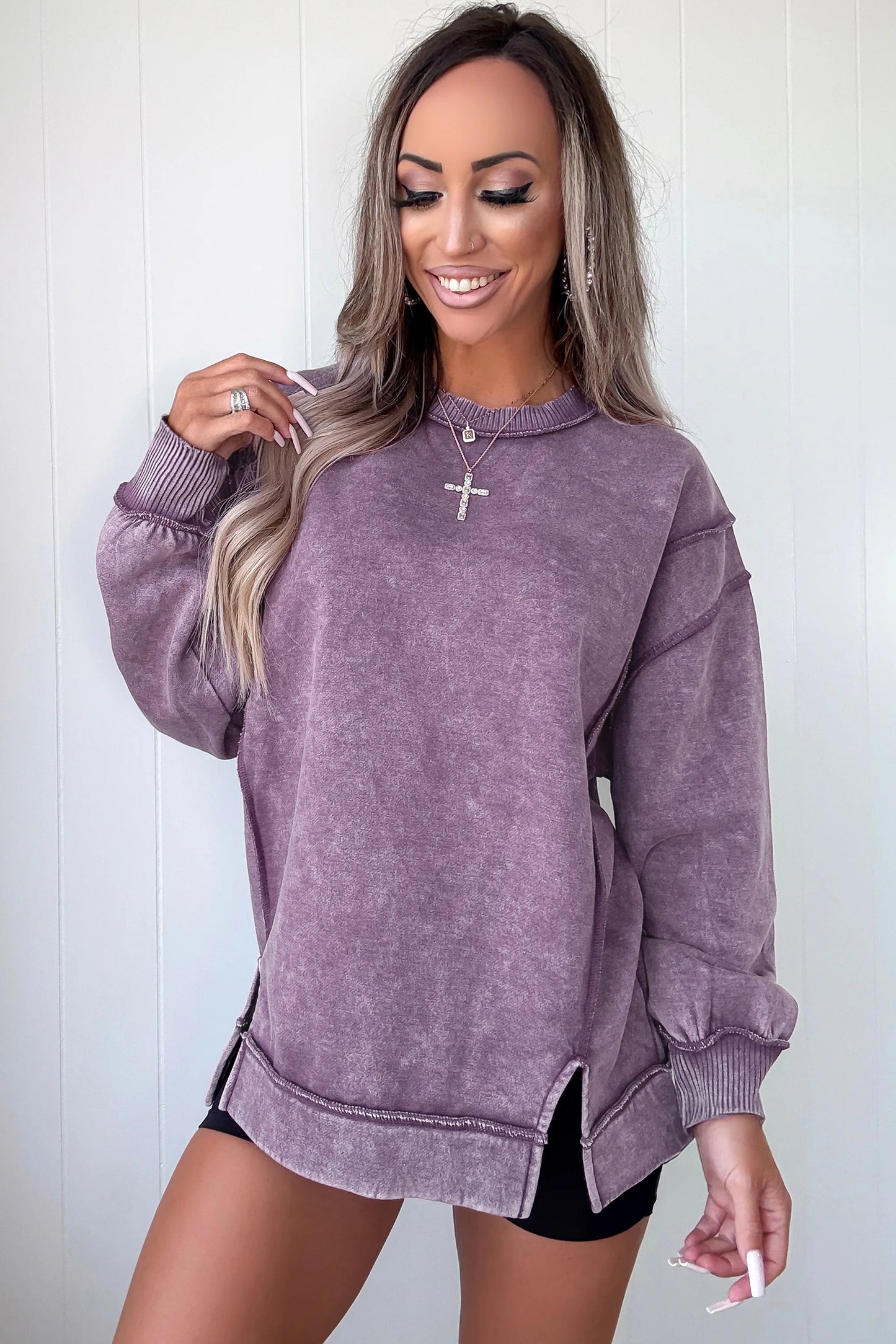 Woman wearing a purple sweatshirt against a white background