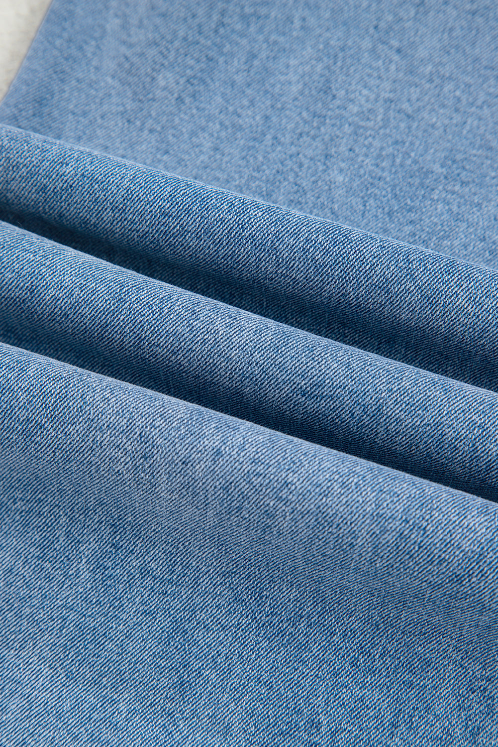 Close-up of blue denim fabric with a subtle pattern