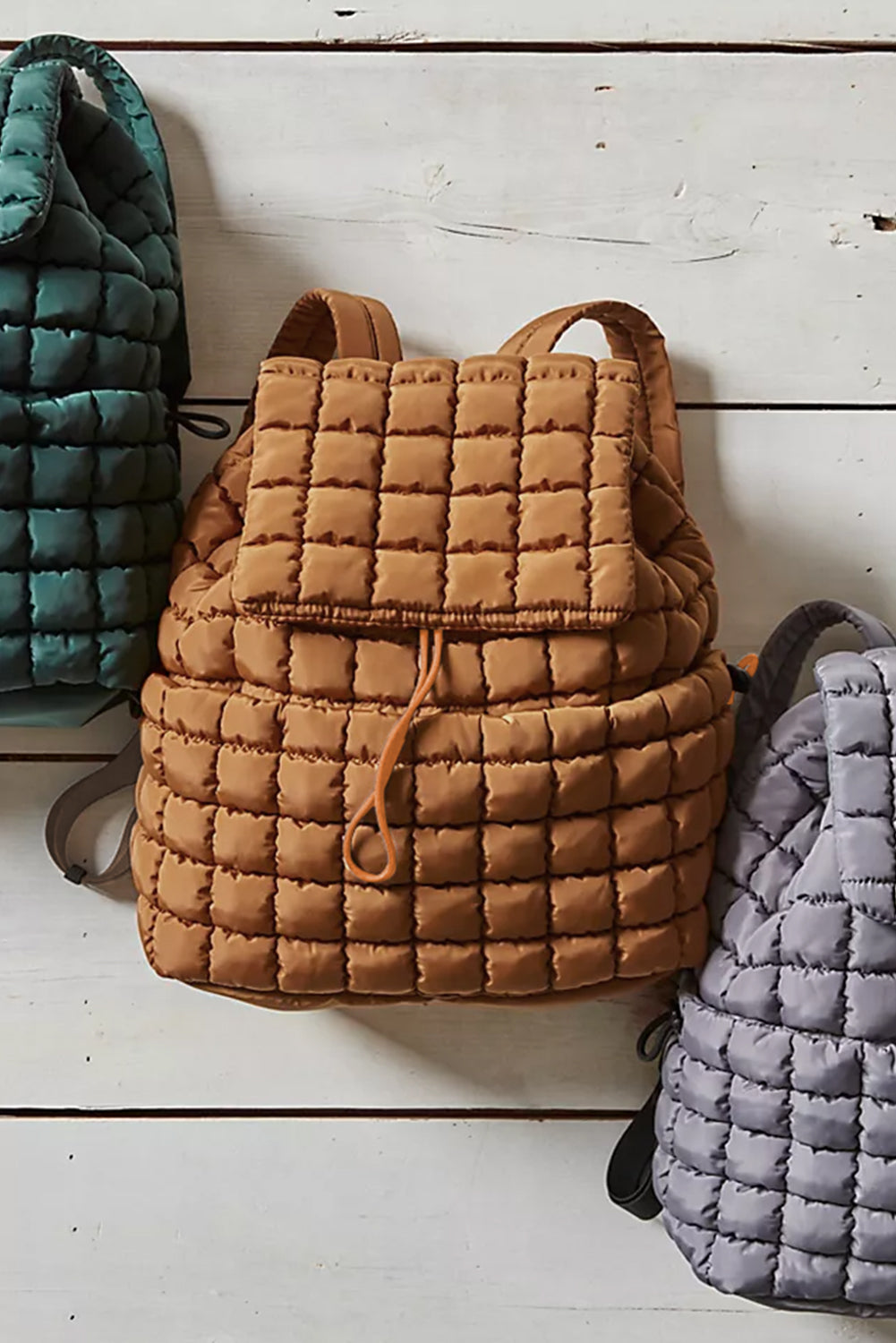 Model showing the opening of a Chic coffee brown Quilted Puffer Flap Backpack 