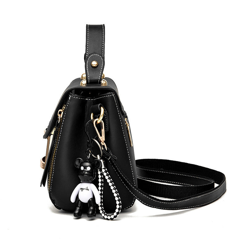 Black backpack with a keychain on a white background