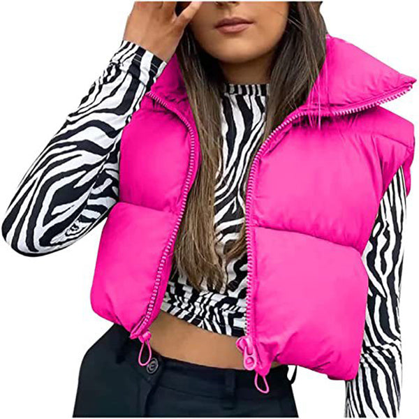 Person wearing a bright pink puffer vest over a zebra print top.