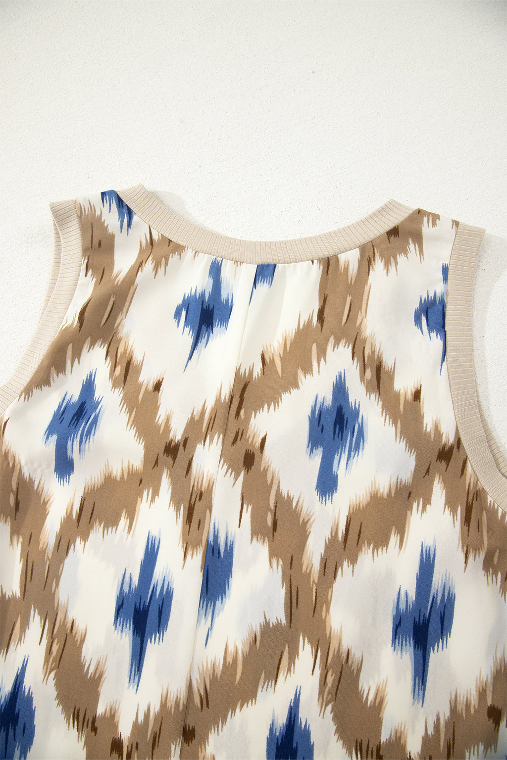 Baby romper with blue and brown abstract pattern on a white background close-up