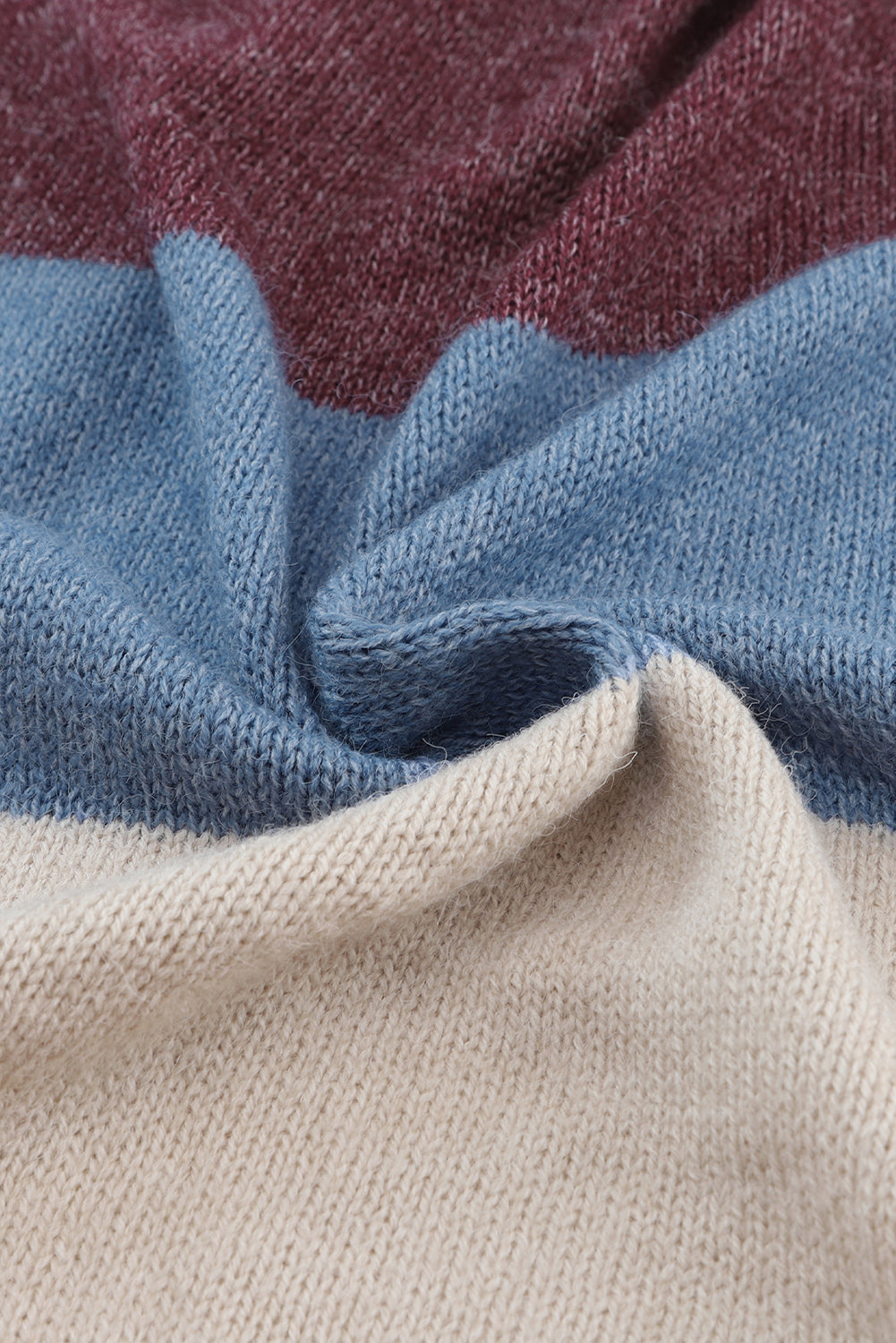 Close-up of fabric with maroon, blue, and beige stripes.