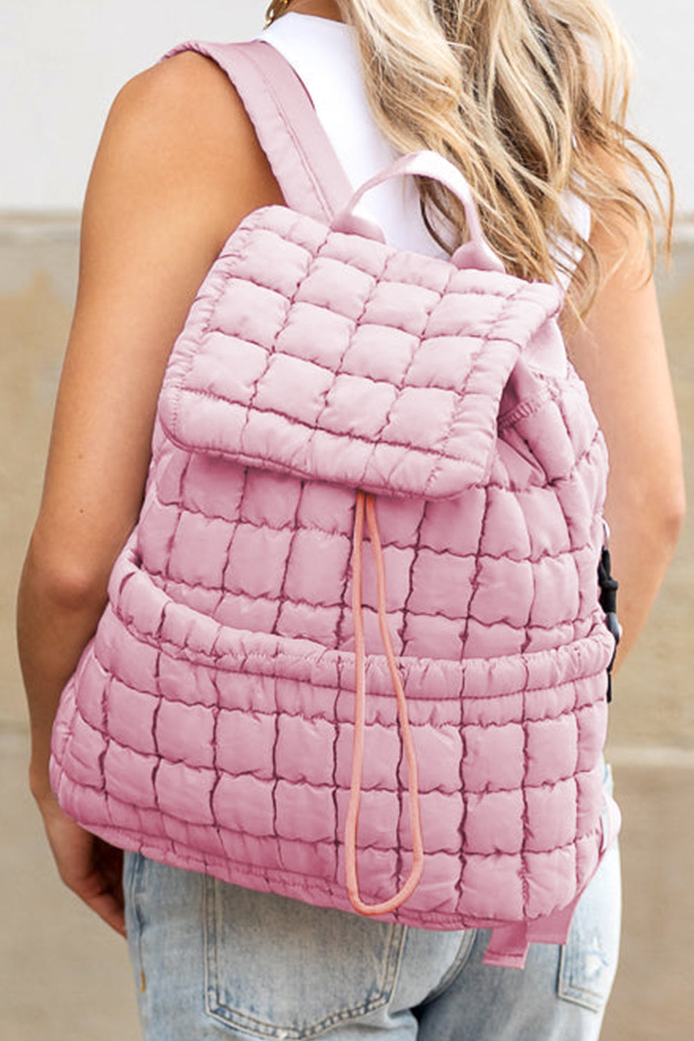 Model wearing a Chic pink Quilted Puffer Flap Backpack across the back