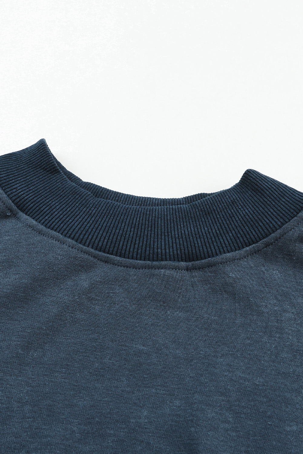Close-up of a dark blue sweater collar on a white background