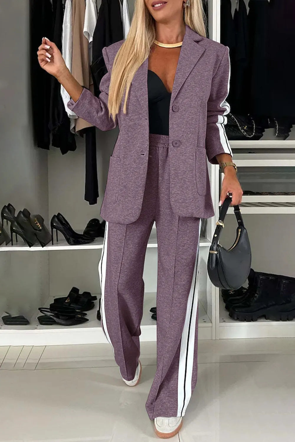 Woman in a purple suit standing in a room with shelves of shoes and clothing.