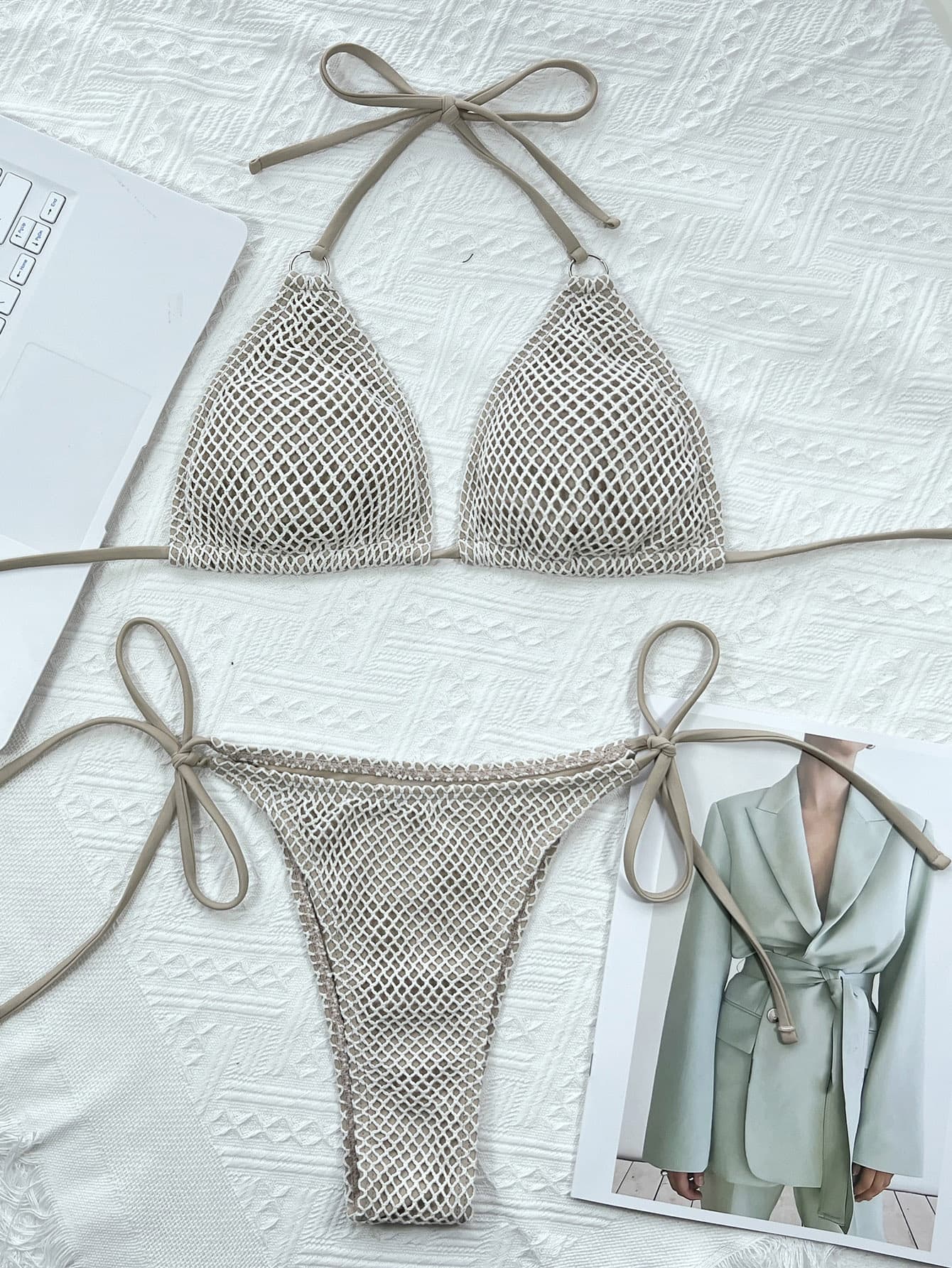 Netted bikini set on a textured surface with a magazine in the background