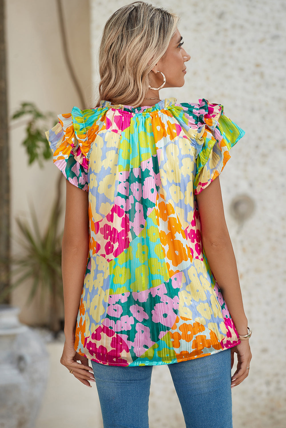 Woman wearing a colorful floral blouse with a blurred background
