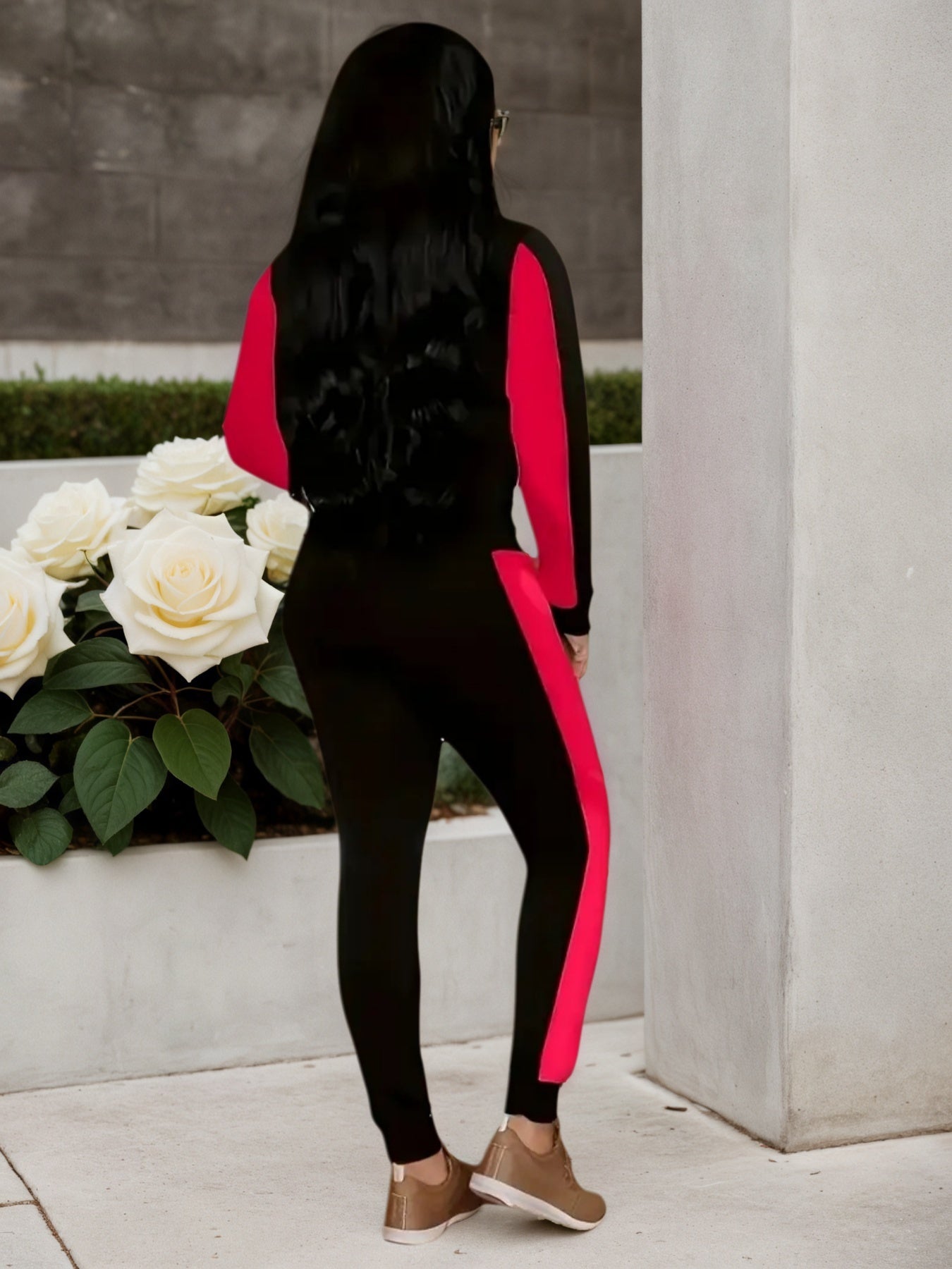 Person wearing a black and red outfit with a white flower arrangement in the foreground