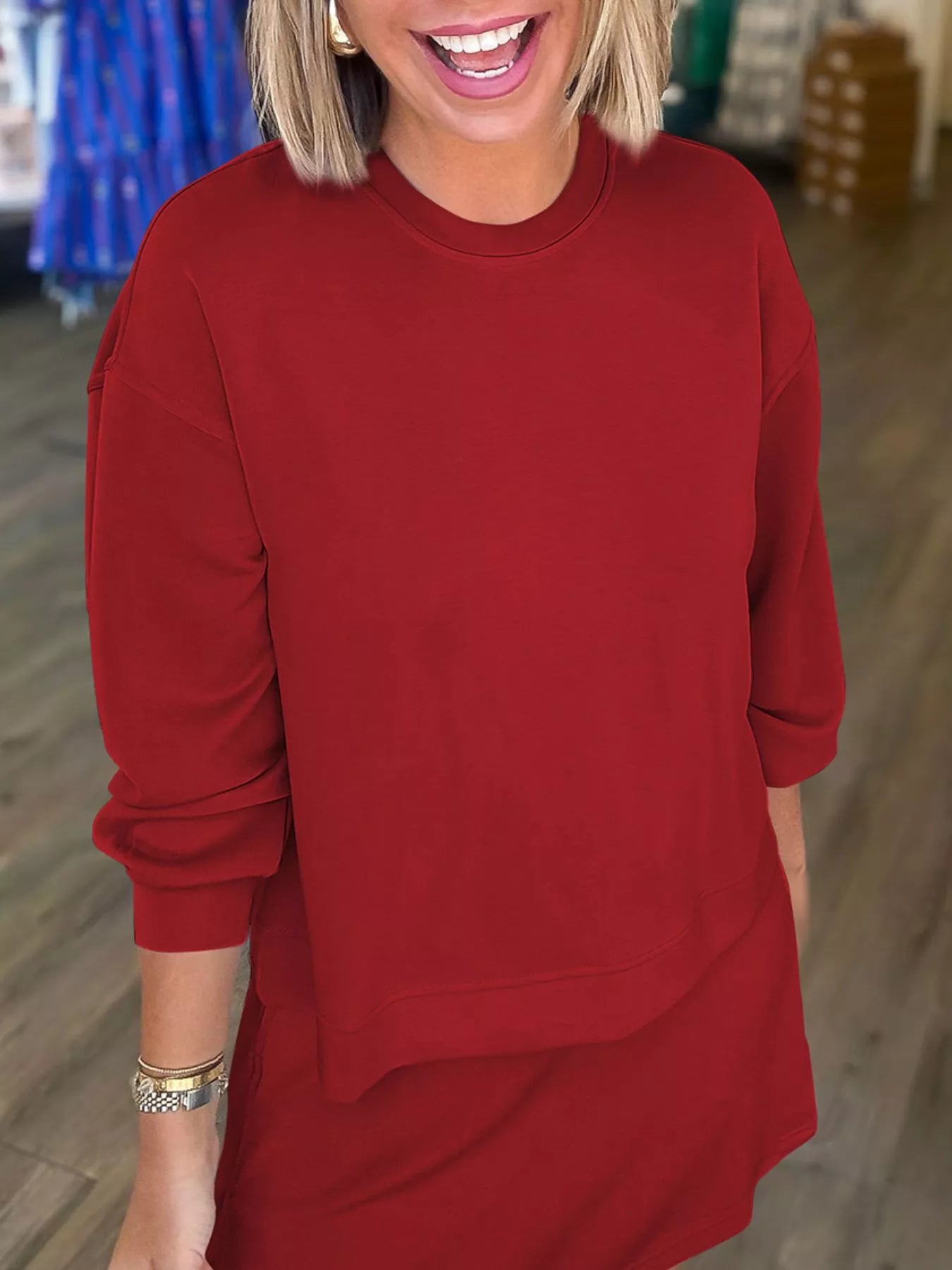 Person wearing a red sweatshirt and skirt in an indoor setting