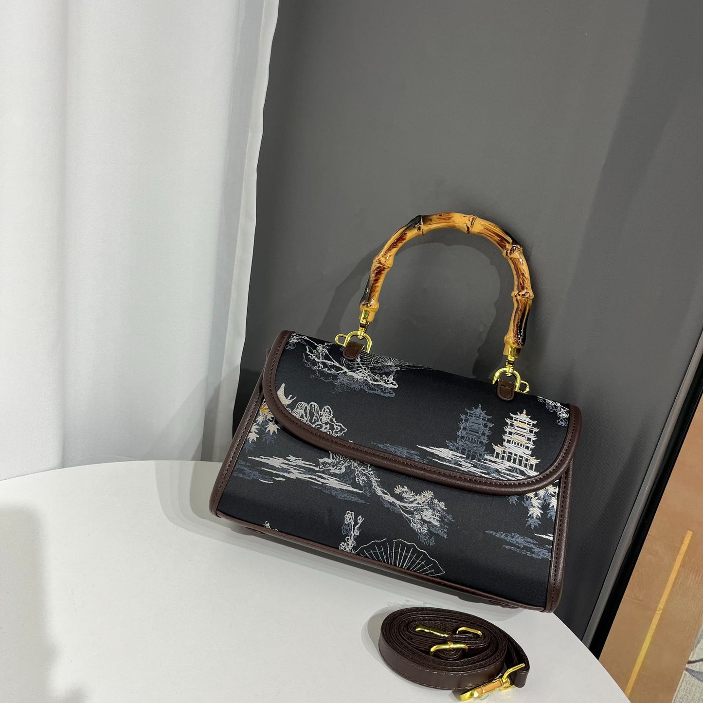 Handbag with bamboo handle on a white surface