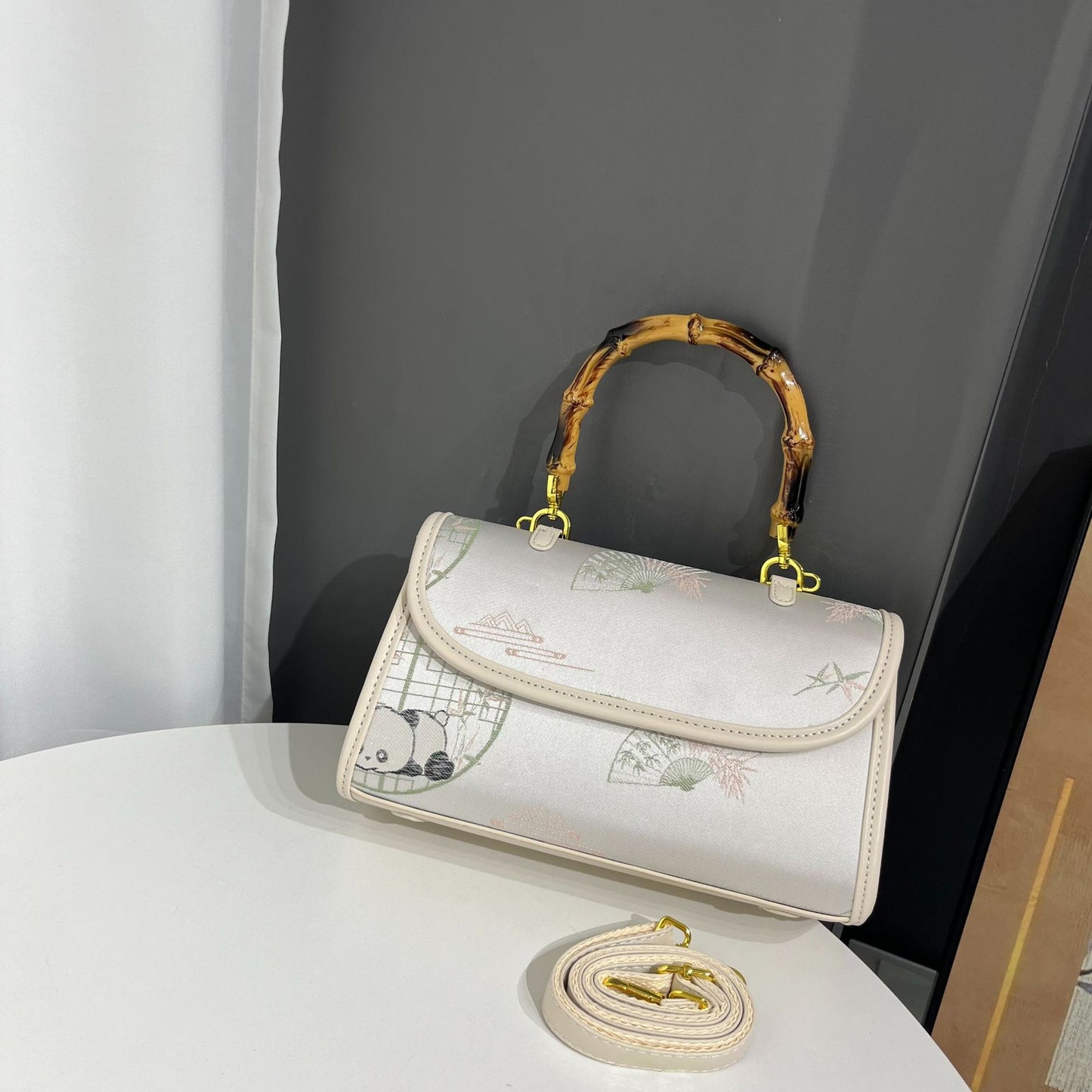 Handbag with cartoon design on a white surface against a gray background