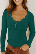 Woman wearing a green ribbed long-sleeve top against a white background