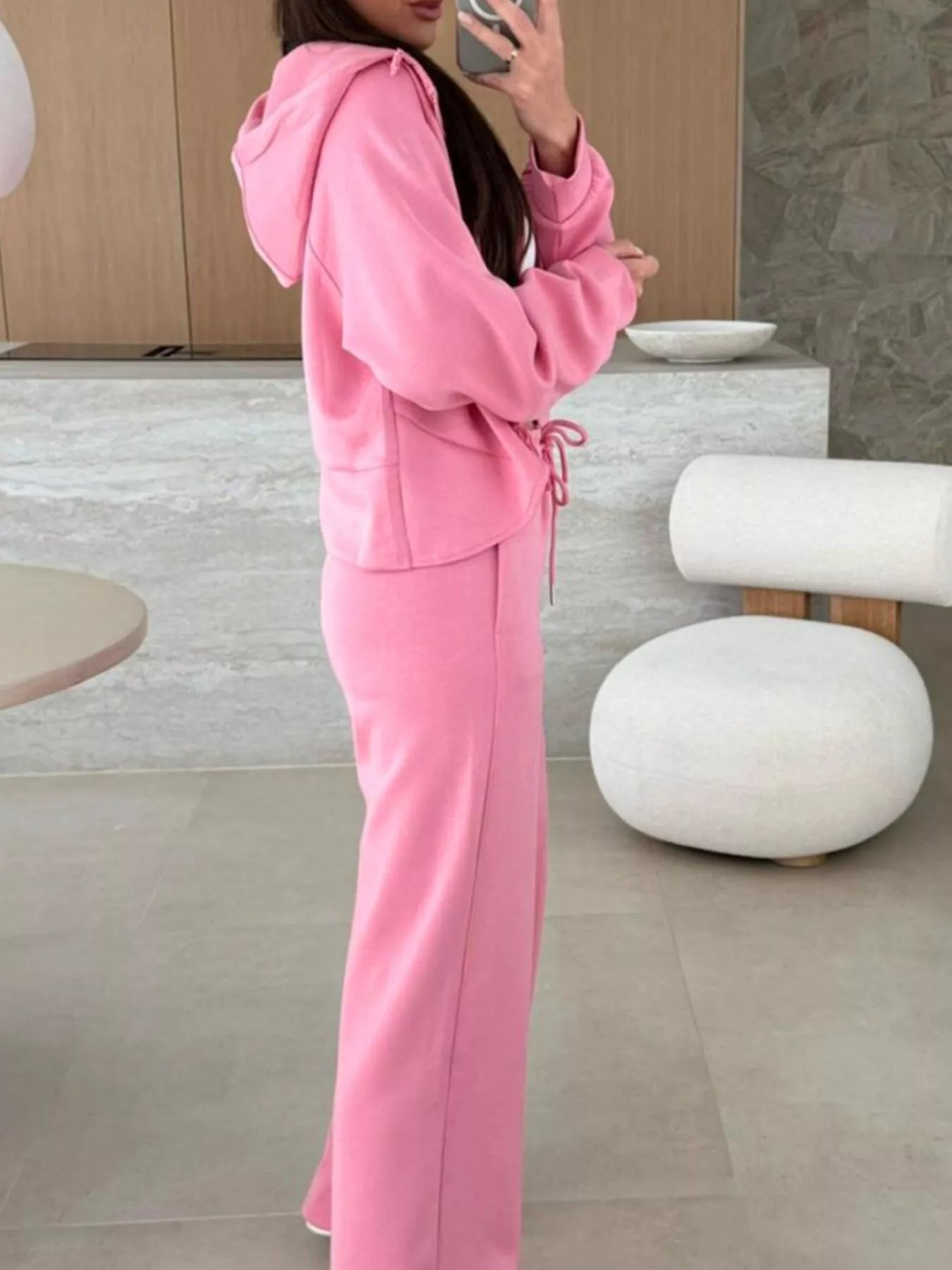 Person wearing a pink tracksuit in a modern indoor setting