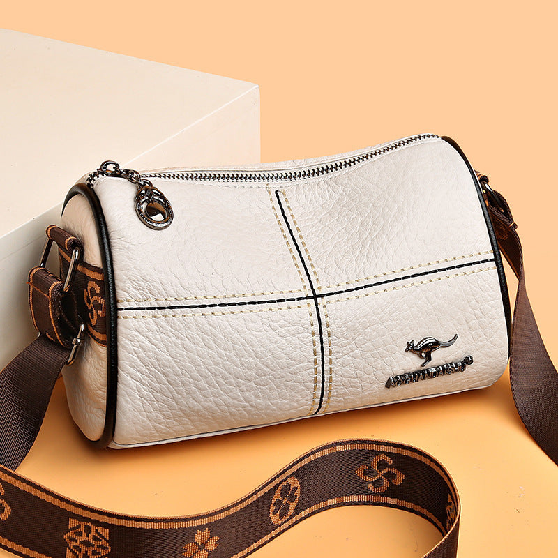 White handbag with brown strap on a beige background