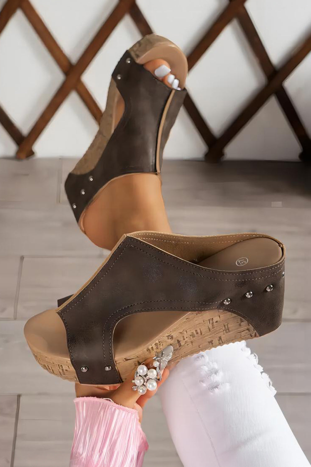 Brown wedge sandals held by a person 