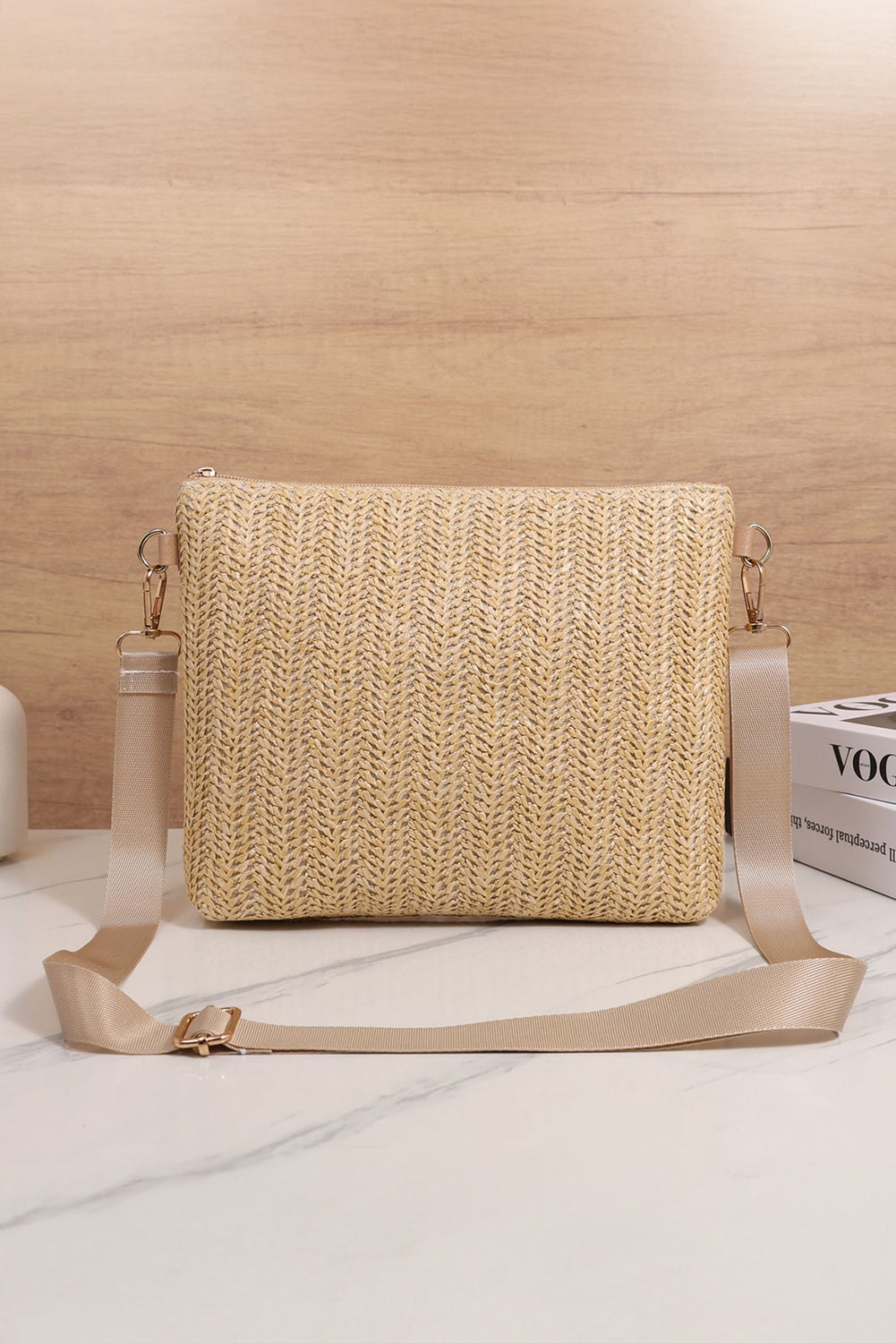 Woven beige handbag with a strap on a light wooden surface